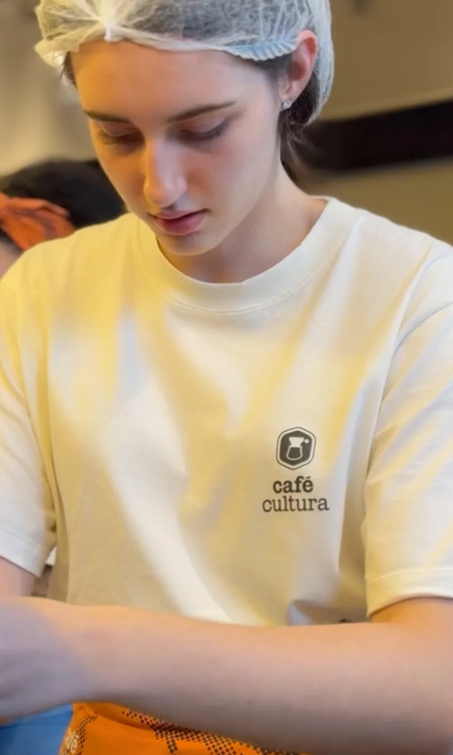 Colaboradora do Café Cultura com camiseta Aprons em produção